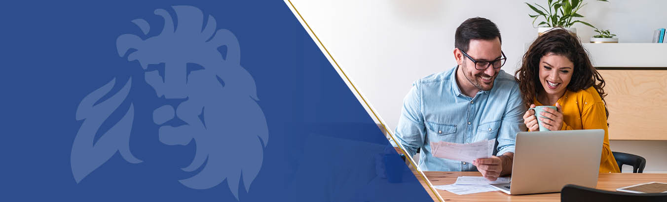 Happy couple sitting in front of laptop